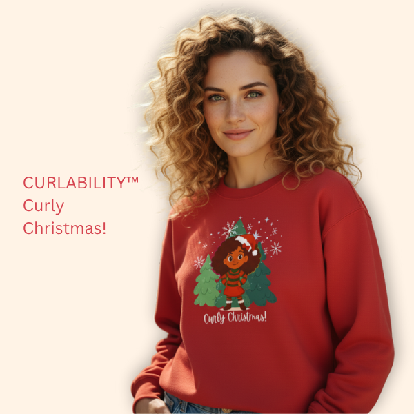 Smiling woman with curly hair wearing a red “Curly Christmas” sweatshirt, posing against a soft beige background.
